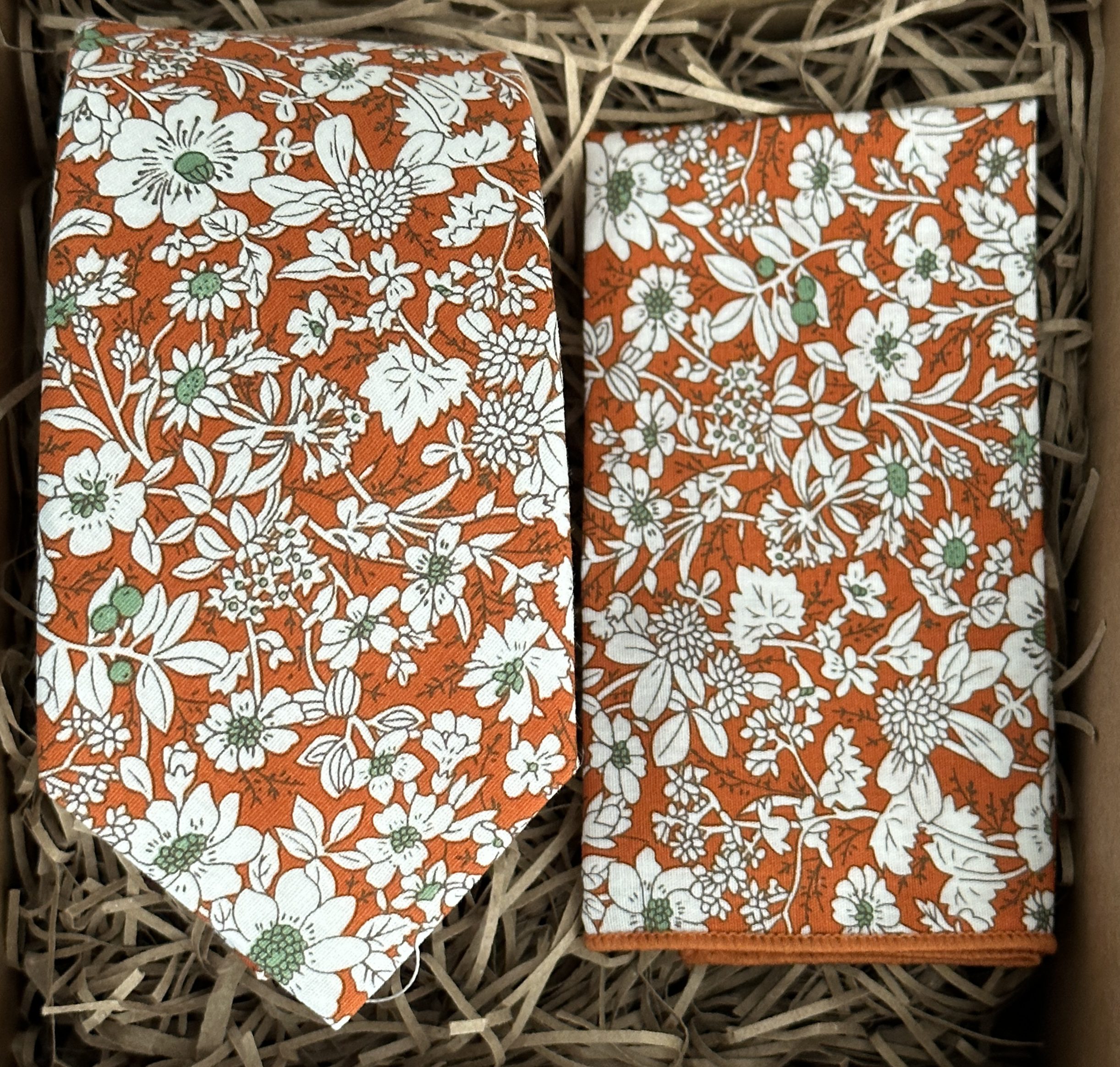 A photo of an orange floral tie and pocket square
