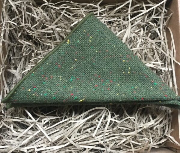 A photo of a moss greenc wool pocket square with coloured flecks in the wool