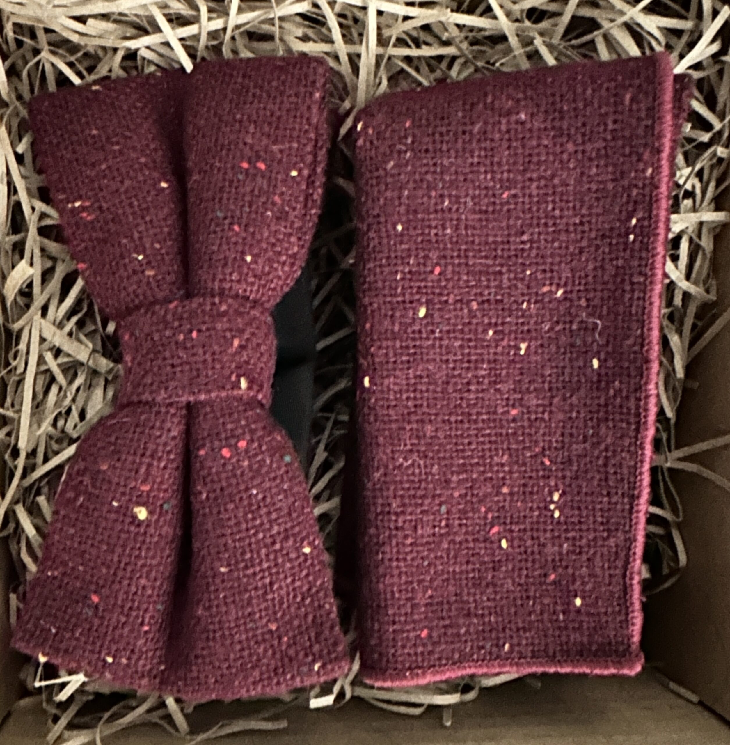 A burgundy bow tie and pocket square set in flecked wool