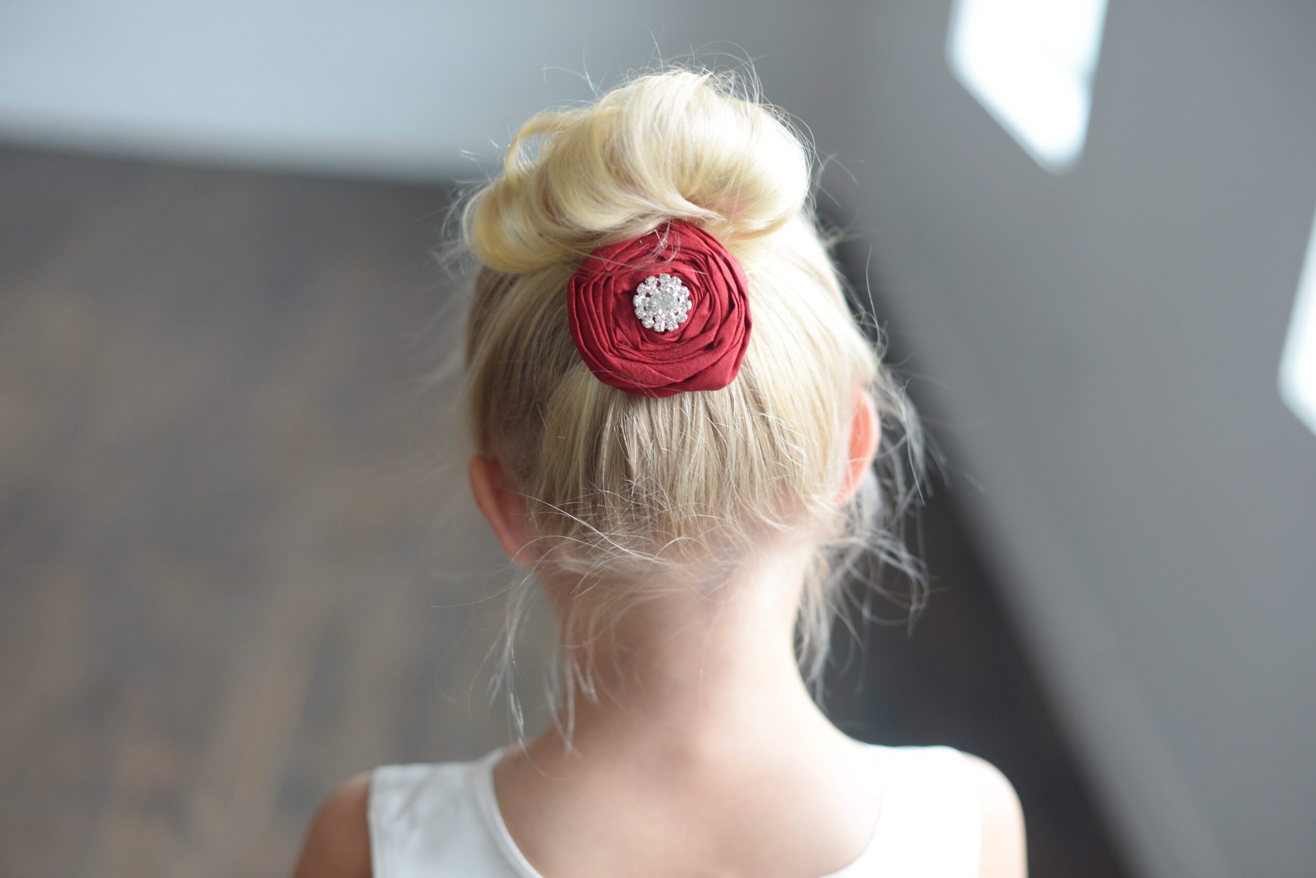 A photo of an english rose flower girl hair clip in red silk