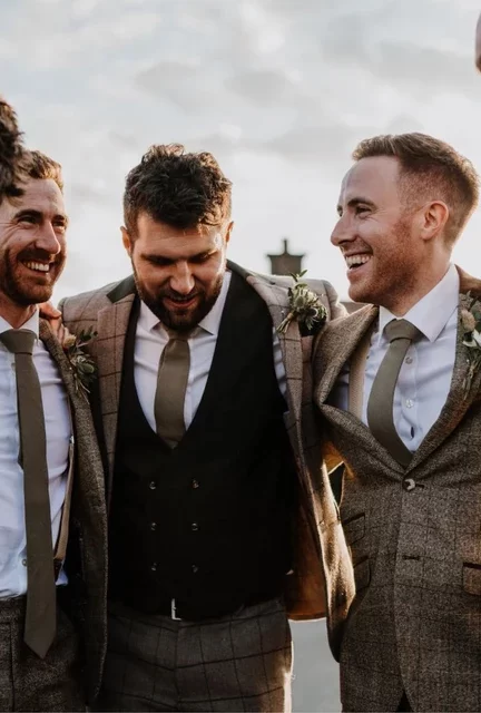 A photo fo a group of groomsmen wearing a sage green cotton tie