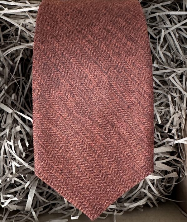 A photo of a burnt orange cotton tie ideal for grooms and groomsmen