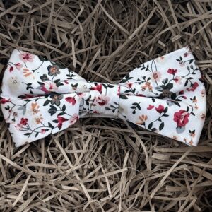 A photo of a pink and white floral bow tie that is pre-tied