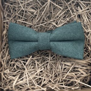 A photo of a dark green brushed cotton bow tie. The bow tie is pre-tied.