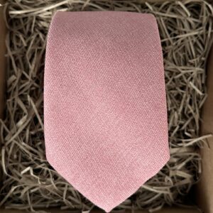 A photo of a blush pink men's necktie in cotton. Also available with a pocket tie and bow tie.