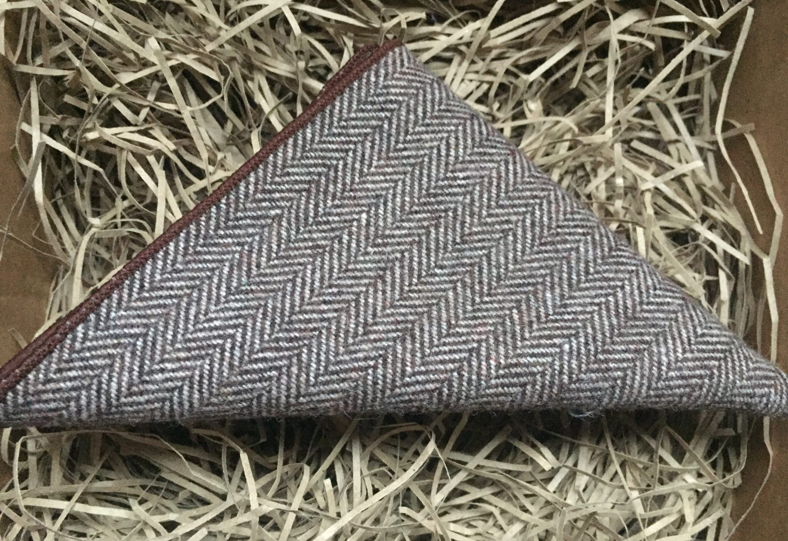 A photo of a brown, herringbone wool pocket square