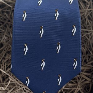 A photo of a navy blue tie with a penguin print. Ideal as a men's gift
