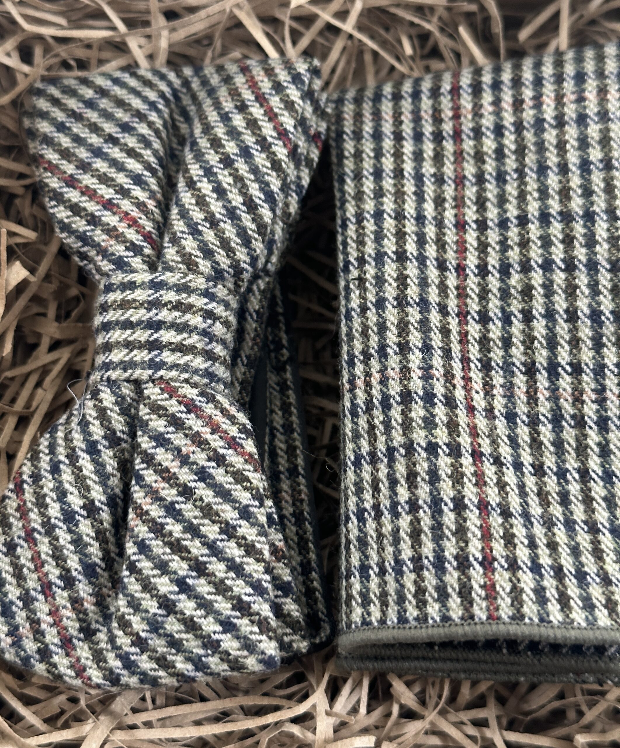 A photo of a checked bow tie and pocket square in wool