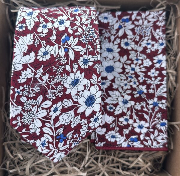 A photo of a red floral tie and pocket square gift wrapped as groomsmen gifts