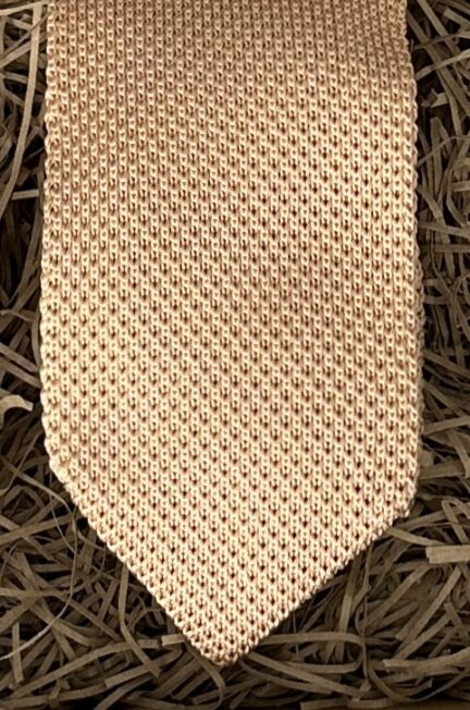 A photo of a champagne coloured knitted tie