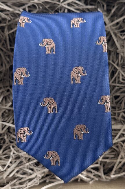 A photo of a mans tie with a elephant pattern on a blue background ideal as a mans gift