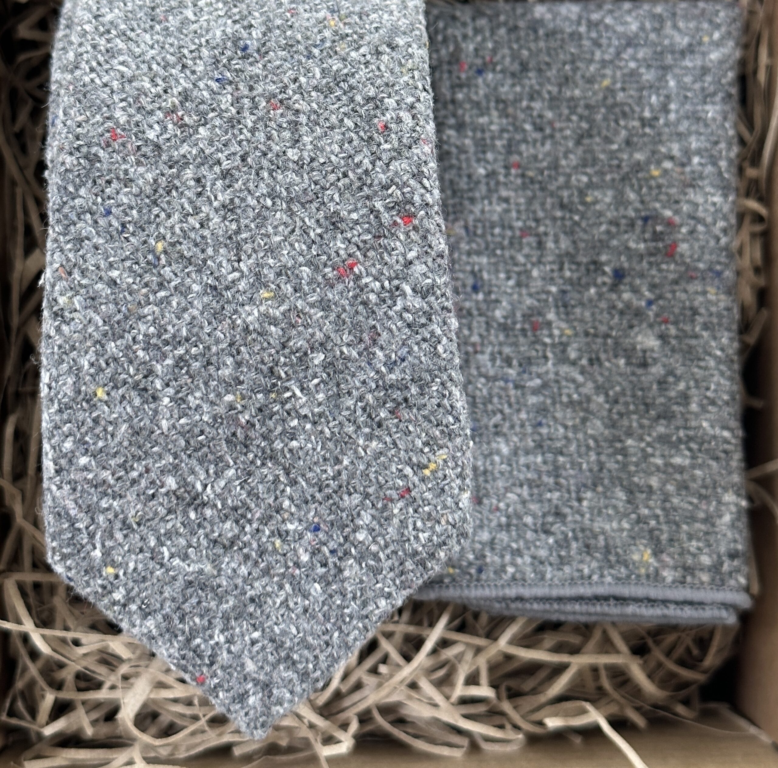 A photo of a grey, flecked wool tie and pocket square set ideal as groomsmen gifts and for weddings
