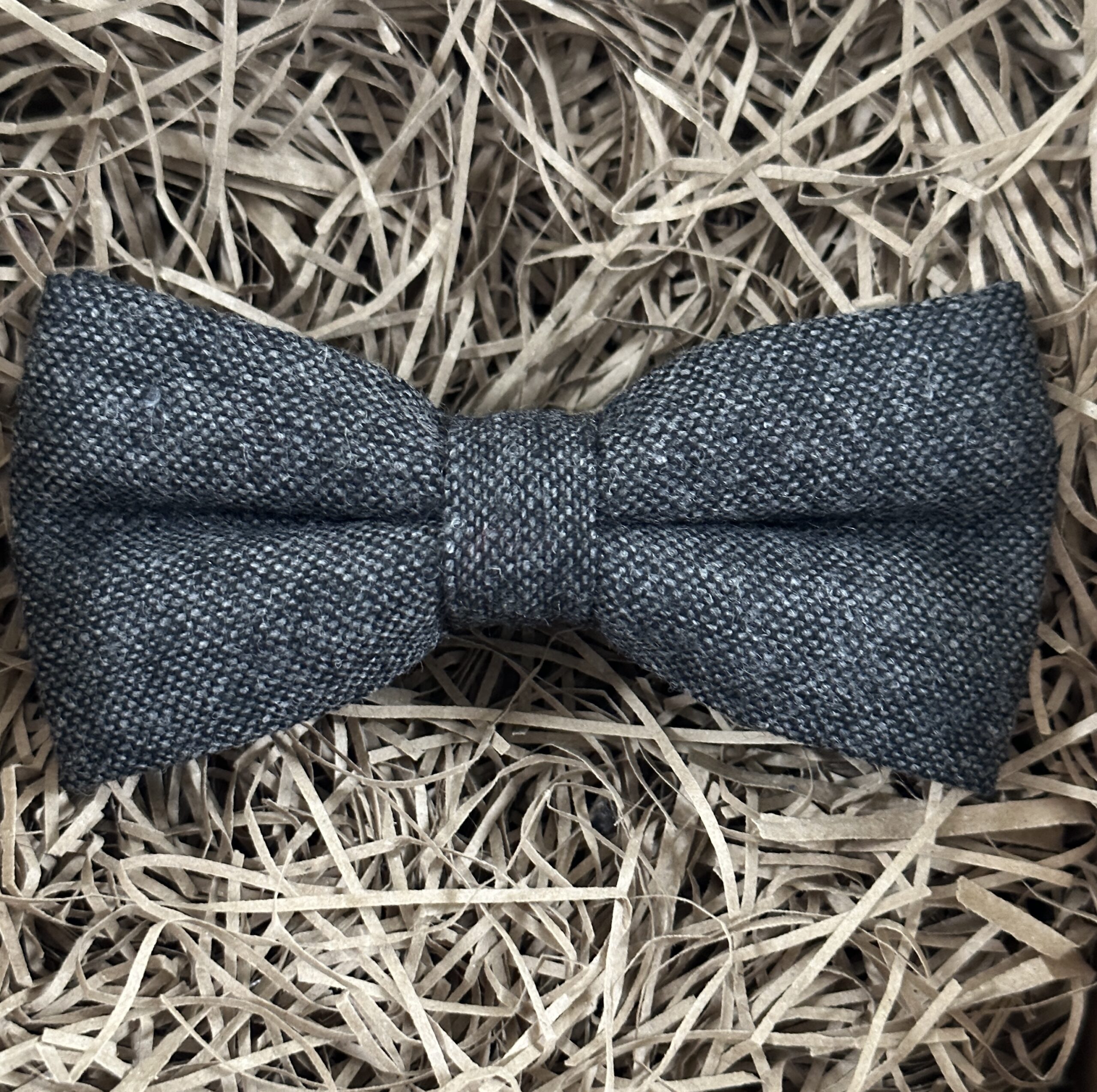 A photo of a dark grey flecked wool bow tie