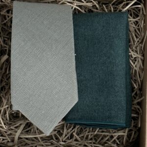 A photo of a sage green cotton mens tie and cream wool pocket square to make a perfect match.