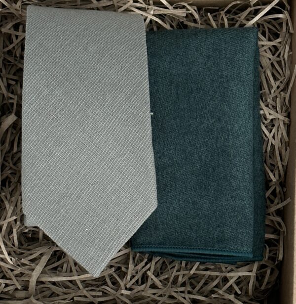 A photo of a sage green cotton mens tie and cream wool pocket square to make a perfect match.