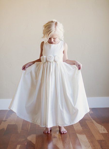 Rustic flower girl dress in ivory and white with ivory roses on the belt.