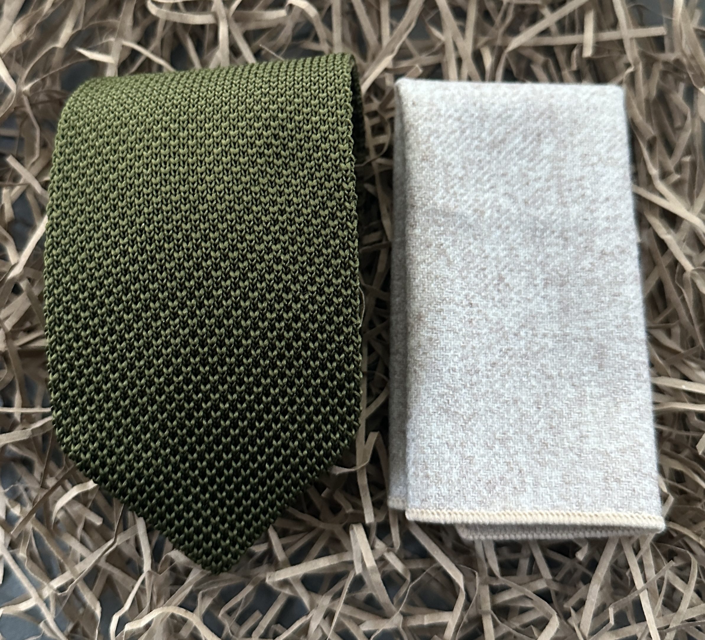 An olive green knitted tie with a cream wool pocket square ideal for men's gifts and wedding attire.