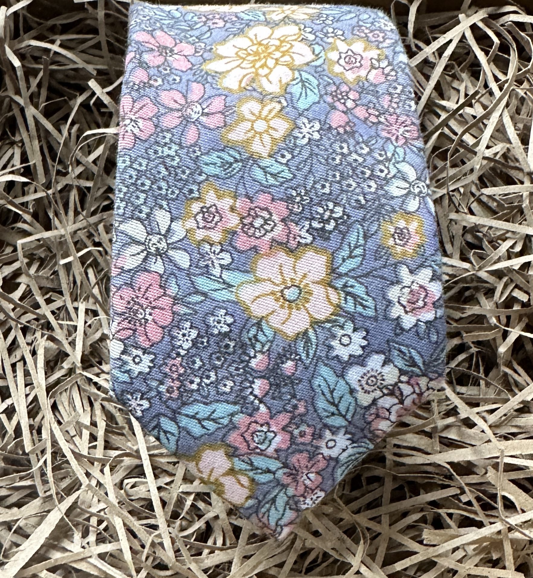 A blue grey floral wedding tie with pink and yellow flowers