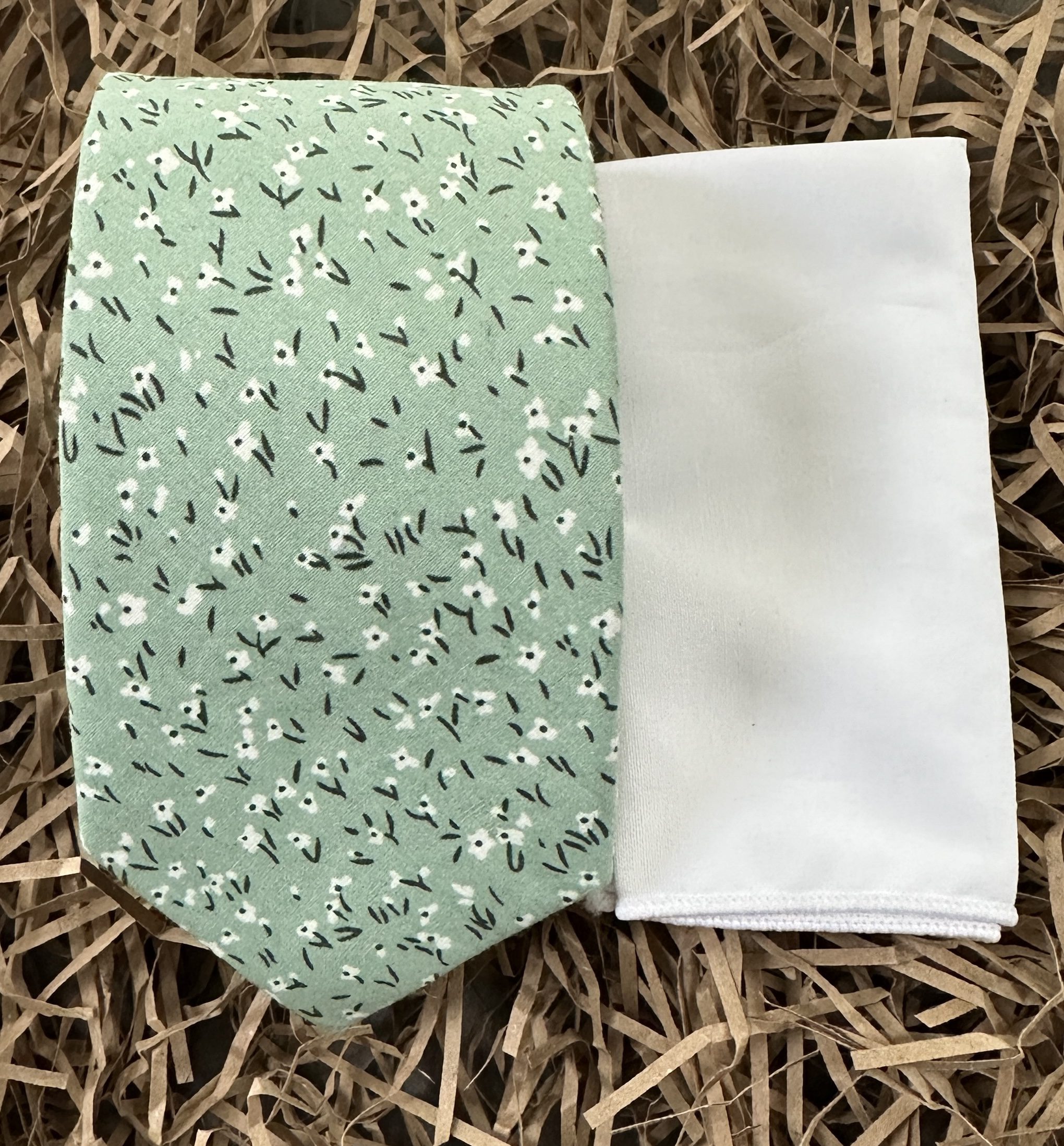A green floral men's tie matched with a white pocket handkerchief for men's gifts, wedding attire and groomsmen gifts for instant gift giving.