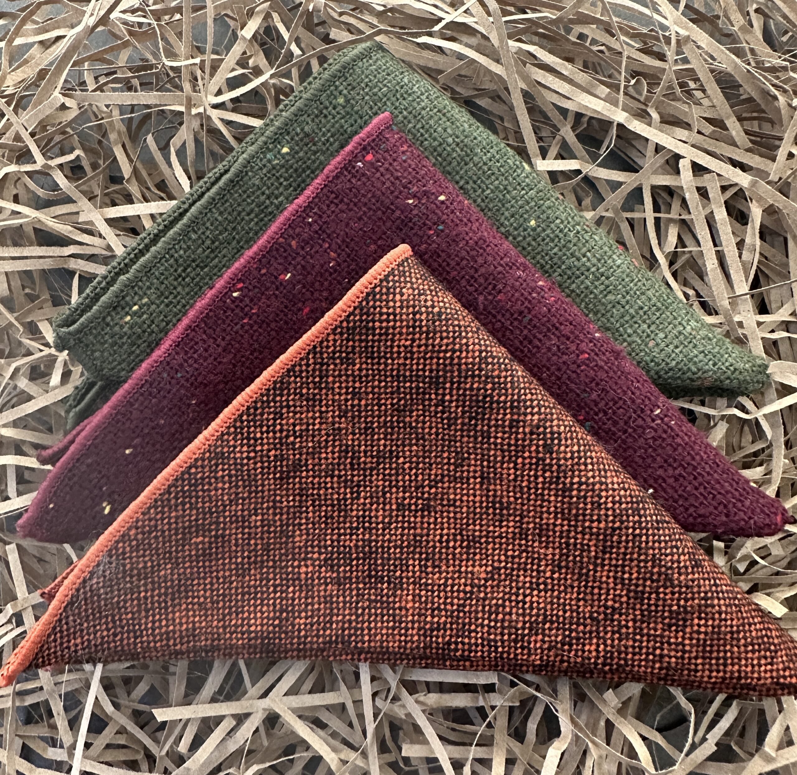 A set of three woollen pocket handkerchiefs in burgundy res, green and burnt orange ideal as groomsmen and mens gifts