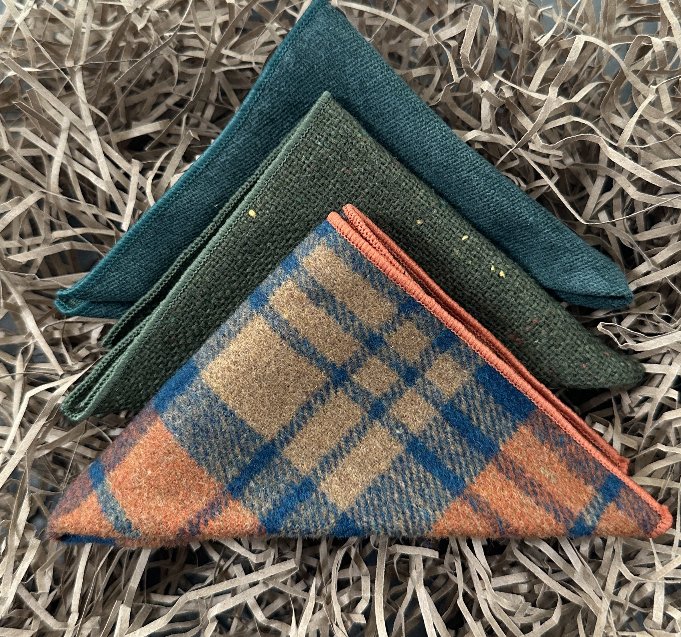 A set of three wool men's pocket handkerchiefs in wool and an orange check. THe set is ideal for men's gifts UK, mens's gifts USA and men's wedding attire.