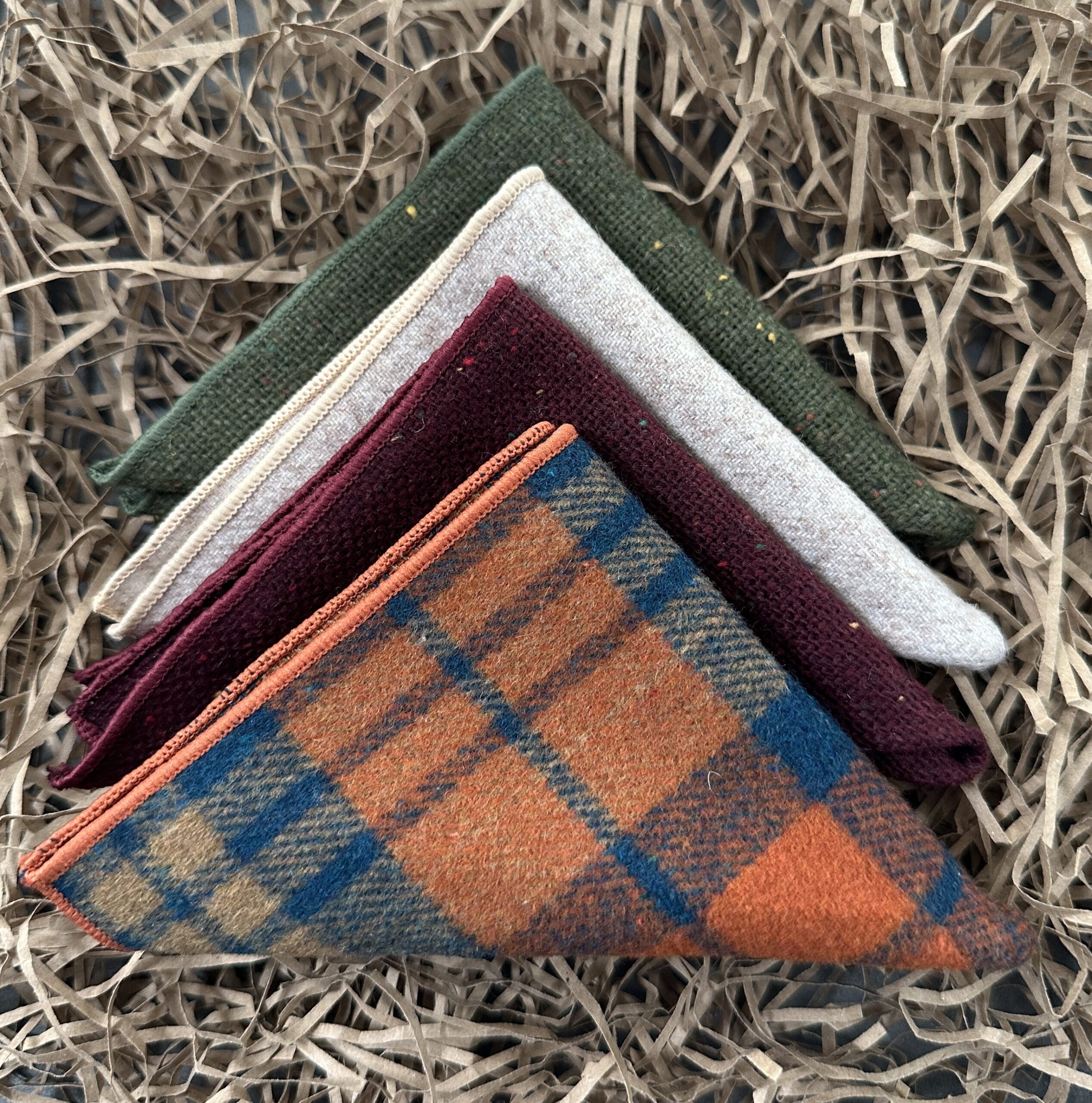 A set of three wool pocket squares for men in red, green and cream wool.