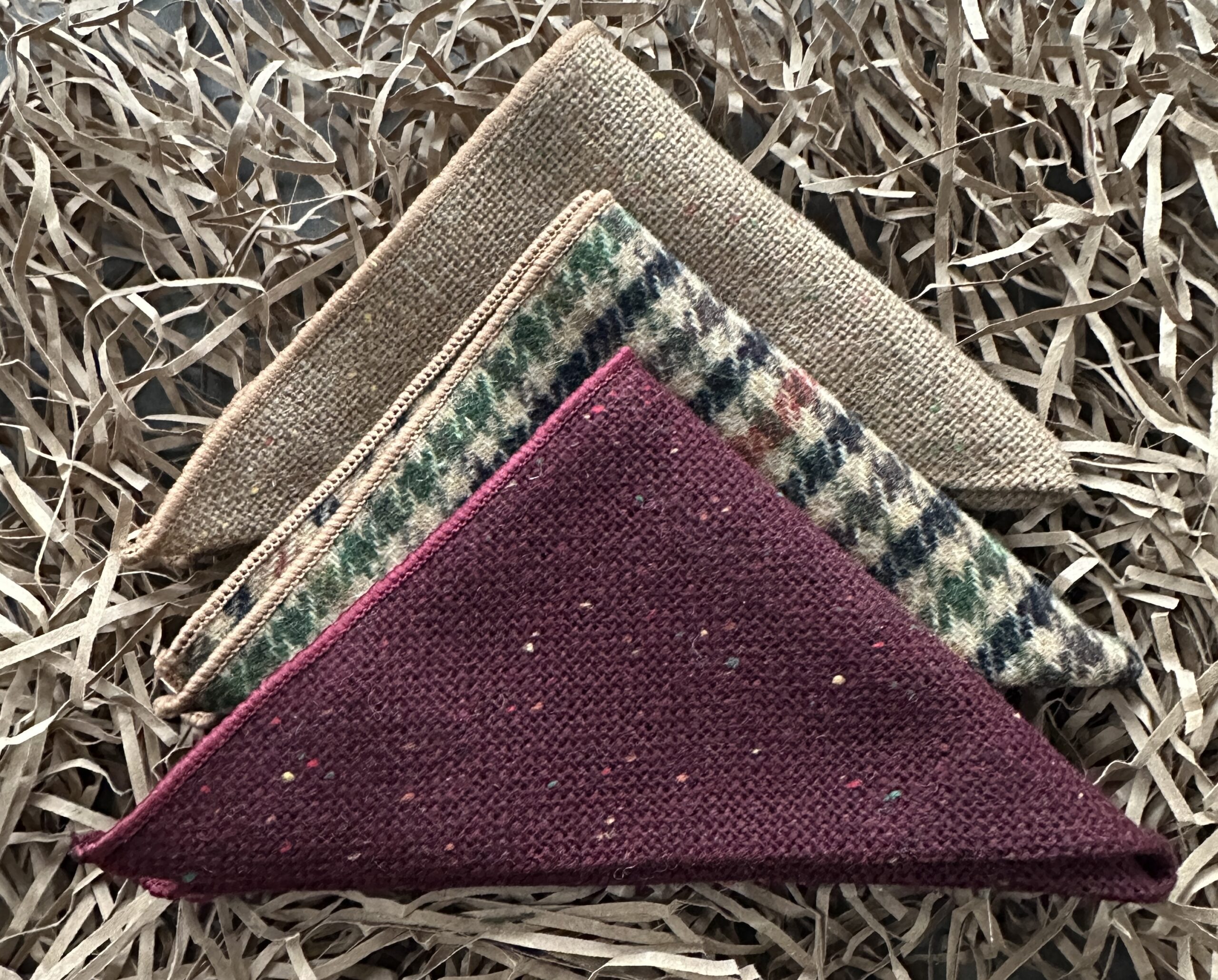 A set of three wool pocket squares for unique groomsmen gifts, best man gifts and gifts for men UK. The set is made of wool and comes in beige, check and red shades.