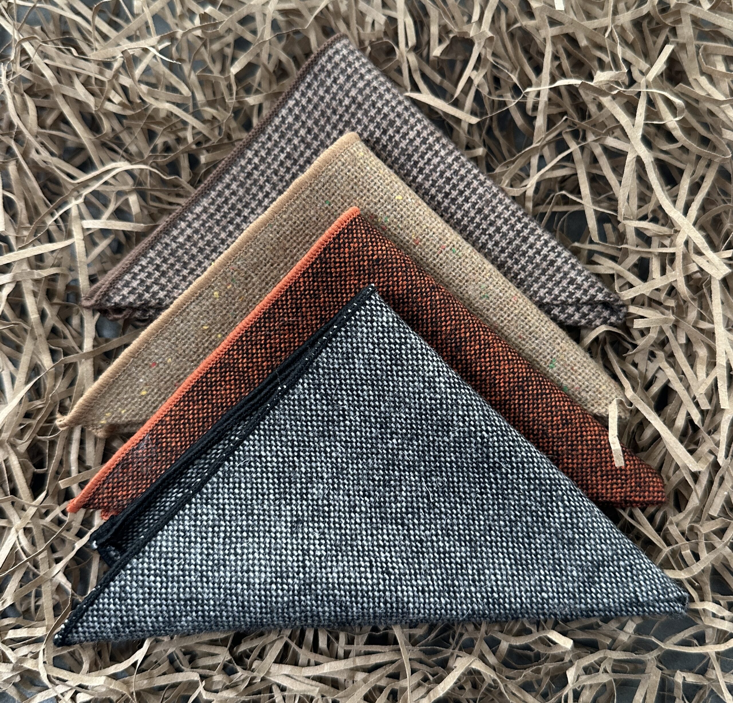 A set of four mens pocket squares in grey orange and brown checked wool for mens gifts, groomsman gifts and best man gifts.