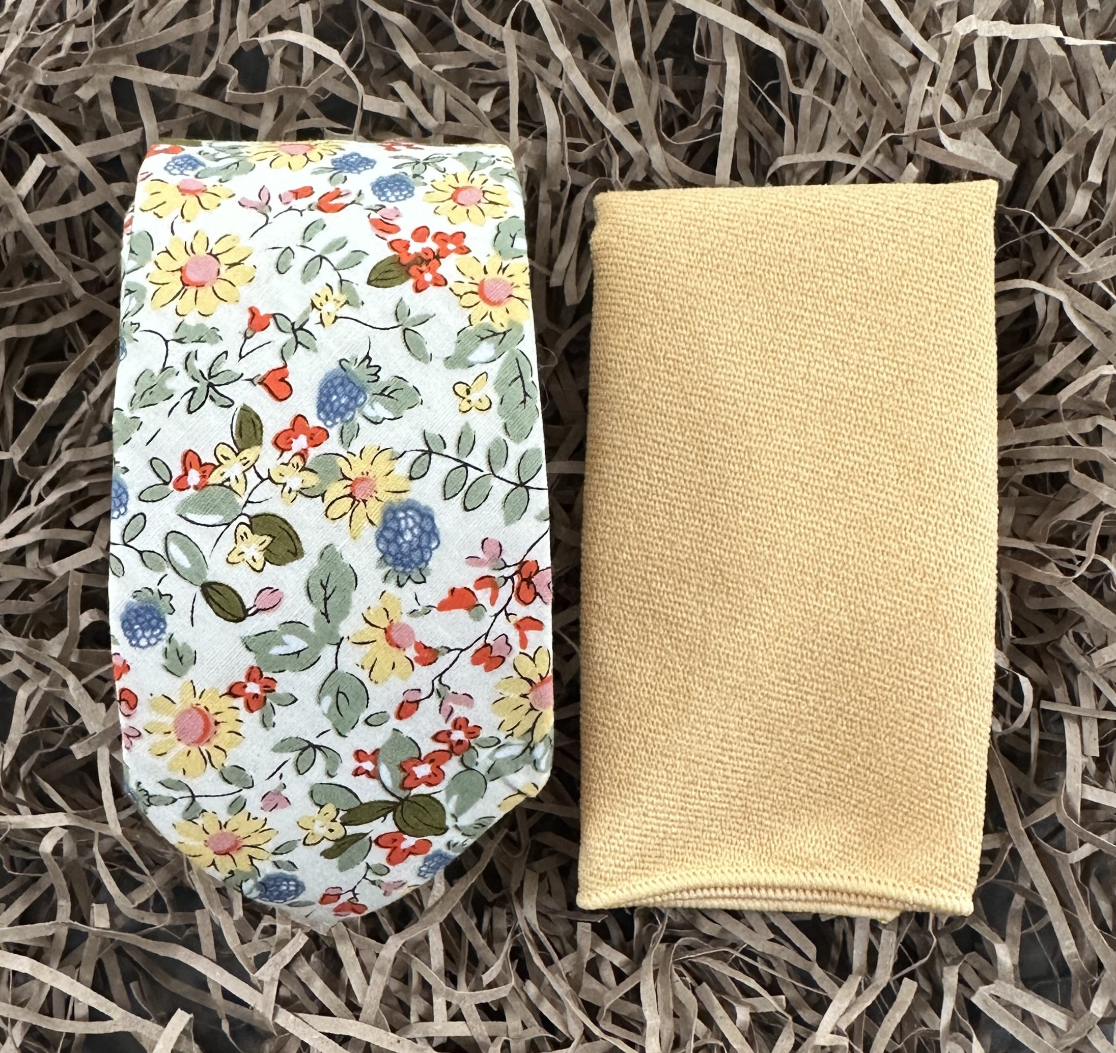 A photo of a yellow floral spring tie for men and women matched with a yellow pocket handkerchief.